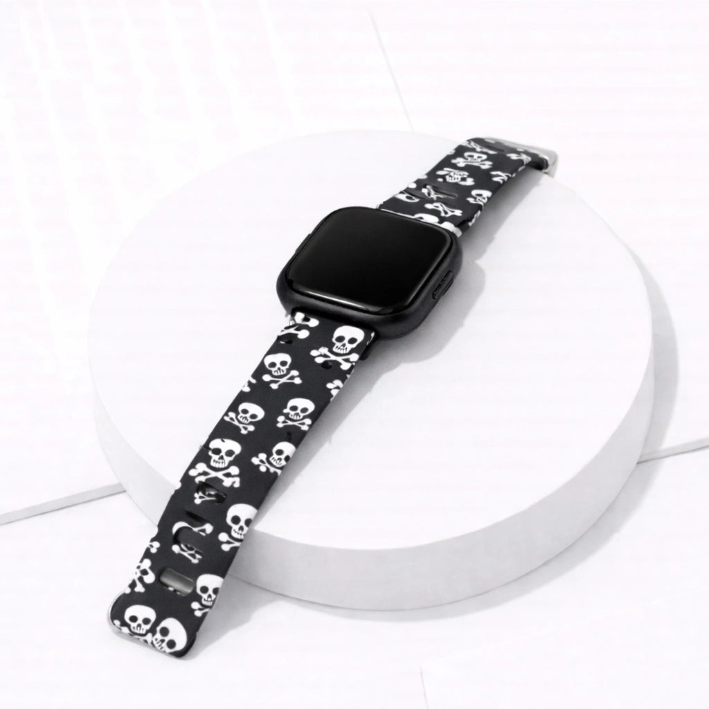 Black silicone skull print strap fitted to a Fitbit Versa 2 displayed in a flat lay