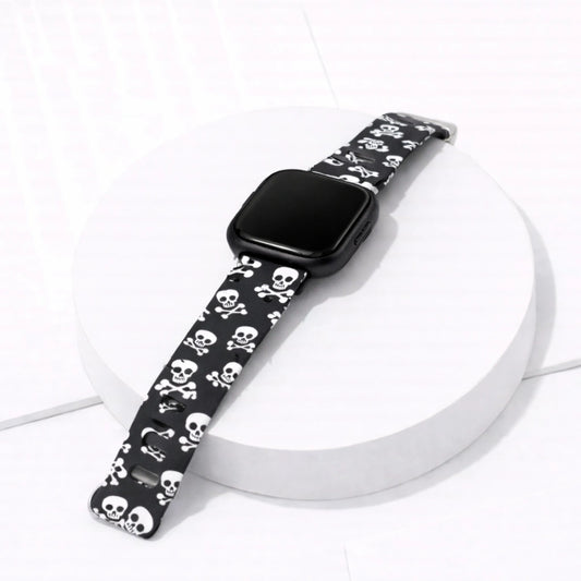 Black silicone skull print strap fitted to a Fitbit Versa 2 displayed in a flat lay