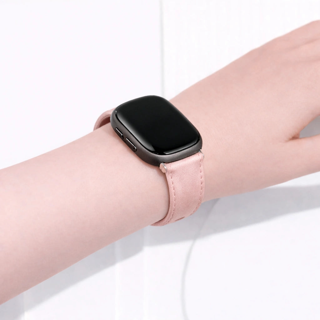 Light pink Fitbit Versa 3 watch band worn on the wrist with a soft leather finish.