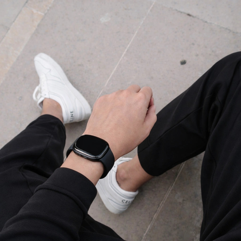 Black silicone strap worn on a Fitbit Versa 4 during everyday casual wear.