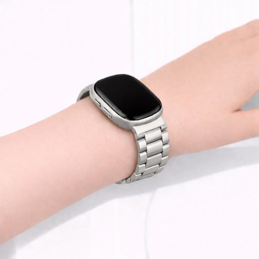 Silver metal link band fitted to a Fitbit Versa 4 on the wrist