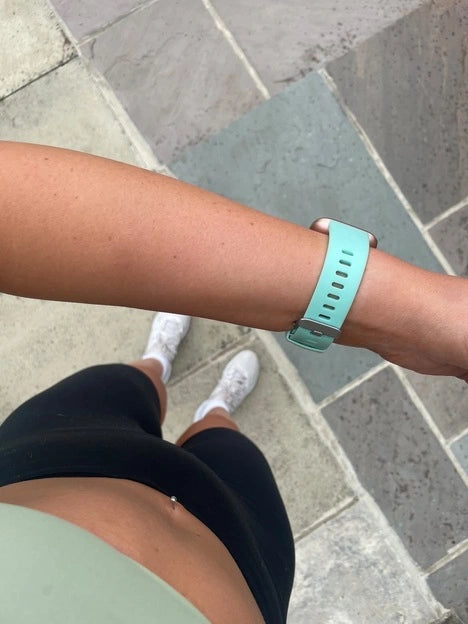 Overhead view of a mint green fitness watch strap during a workout