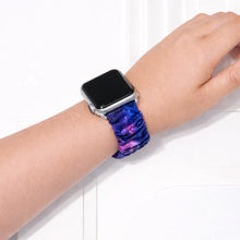 Galaxy print scrunchie Apple Watch wristband worn on wrist with blue and purple space pattern