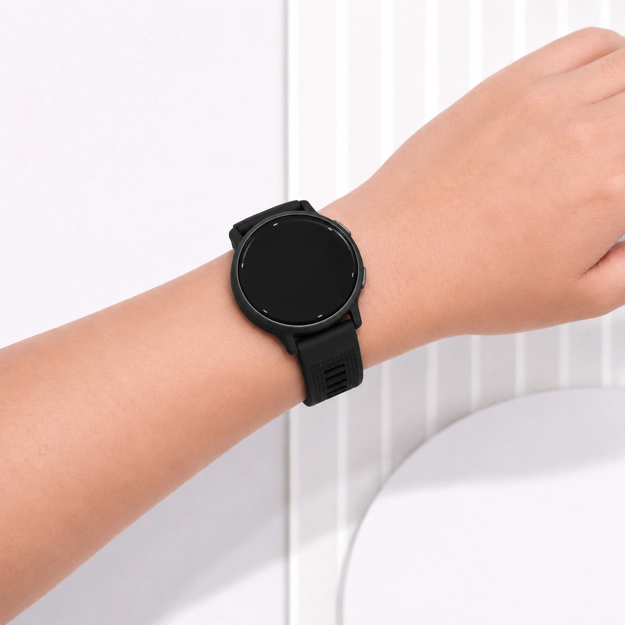 Close-up of a black Garmin Vivoactive 5 silicone strap worn on the wrist.