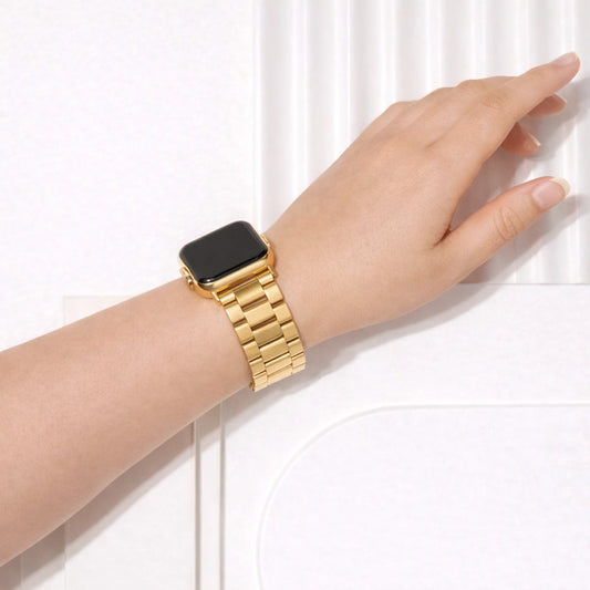 Gold stainless steel Apple Watch band in metal link style worn on wrist