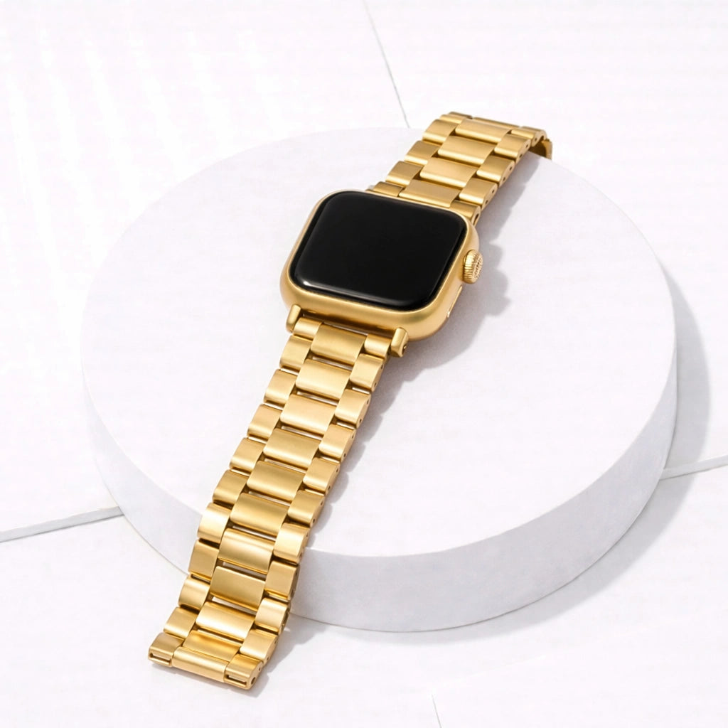 Gold stainless steel Apple Watch strap with metal link bracelet design displayed on white stand