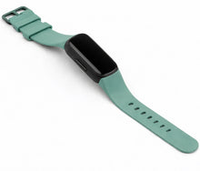 Green silicone strap for Fitbit Inspire 3 displayed on a white background