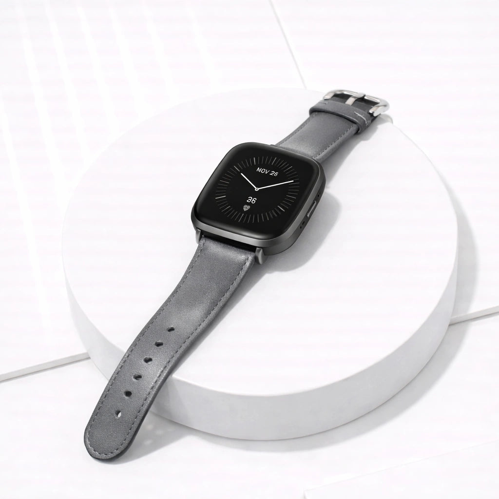 Grey leather band for Fitbit Versa 3 displayed flat with stainless steel buckle and classic finish