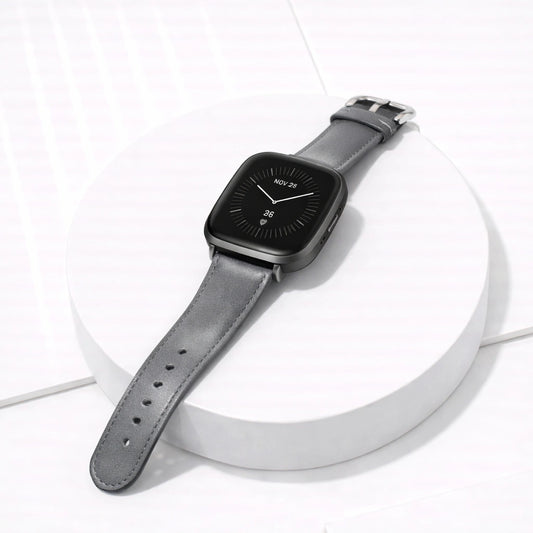 Grey leather band for Fitbit Versa 3 displayed flat with stainless steel buckle and classic finish