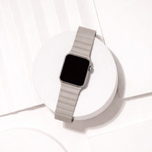 Grey two-part leather Apple Watch band displayed on a white platform.