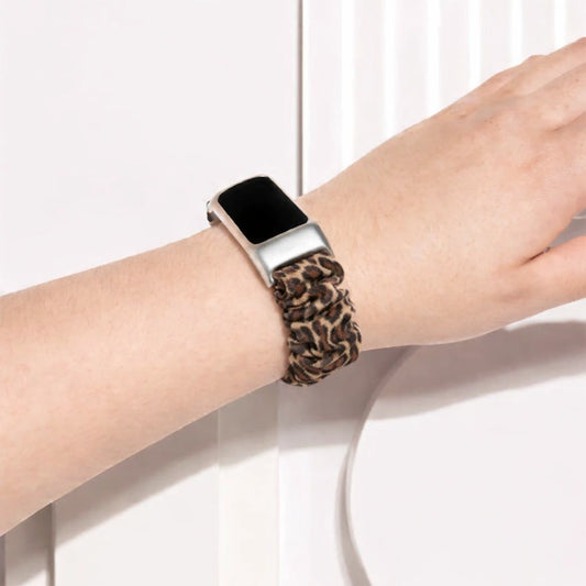 Fitbit Charge 6 worn with a leopard print scrunchie strap on the wrist