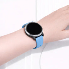 Garmin Venu smartwatch worn with a light blue silicone sport band