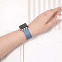 Light blue leather Apple Watch band worn on the wrist.