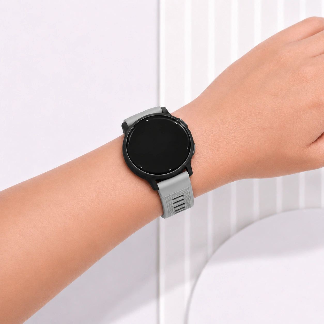 Light grey silicone strap fitted to a Garmin Forerunner 165 smartwatch.