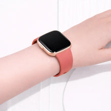 Light pink Fitbit Versa 2 band worn on the wrist with a slim, comfortable fit