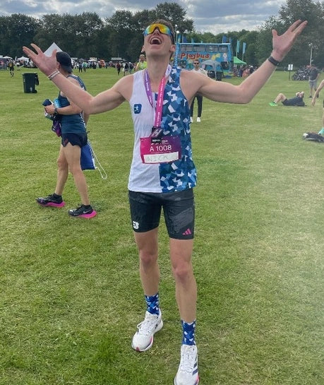 Marathon runner celebrating at the finish line, wearing a fitness smartwatch with a breathable sports strap, ideal for endurance athletes.