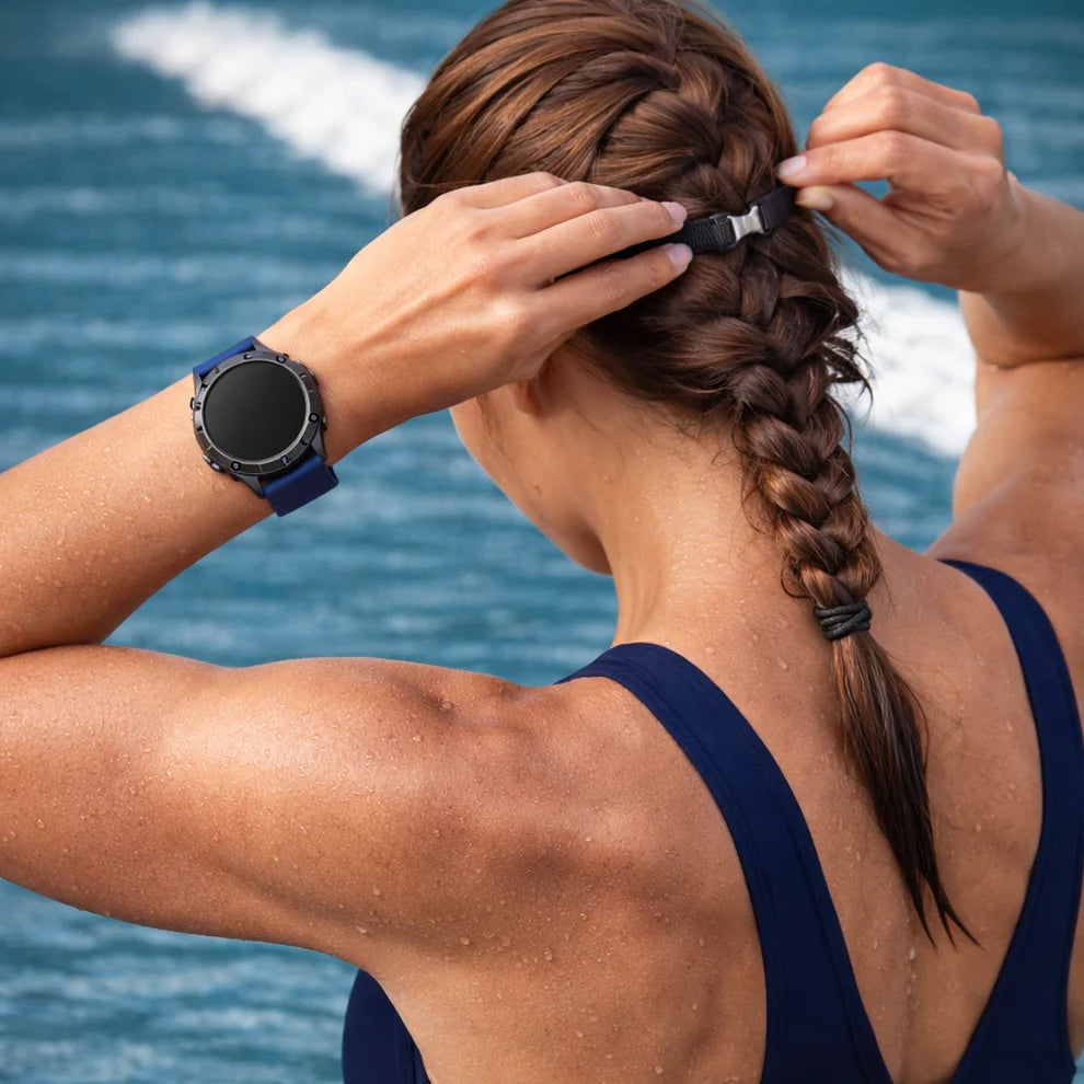 Garmin Fenix 8 with navy silicone strap worn for swimming and water-based activities