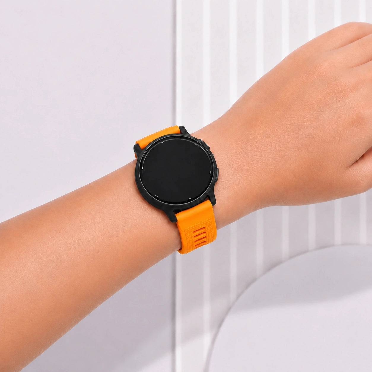 Close-up of an orange Garmin Vivoactive 5 silicone strap worn on the wrist