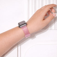 Pink glittery Apple Watch wristband worn on wrist with soft shimmering texture