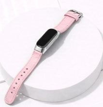 Pink leather watch band for Fitbit Inspire 3 displayed on a stand