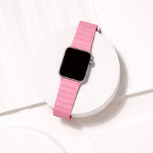 Pink two-part leather Apple Watch strap displayed on a white platform.