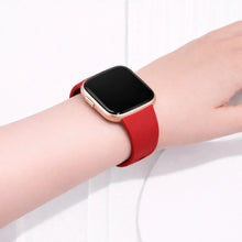 Red Fitbit Versa 2 watch strap worn on the wrist, made from soft silicone for everyday comfort.