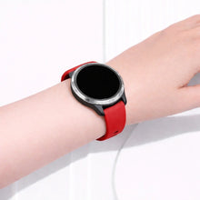 Garmin Venu smartwatch worn with a red silicone sport band