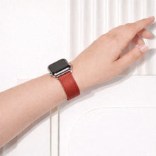 Red leather Apple Watch band worn on the wrist.