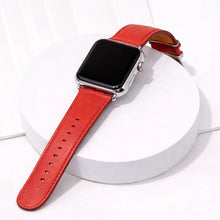 Red leather watch strap for Apple Watch displayed on a white platform.