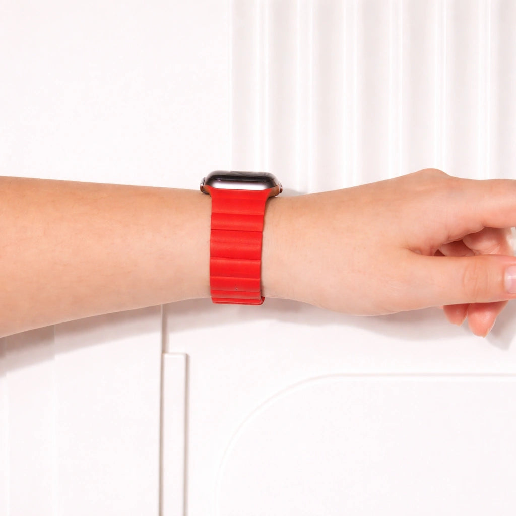 Red two-part leather Apple Watch band worn on the wrist.
