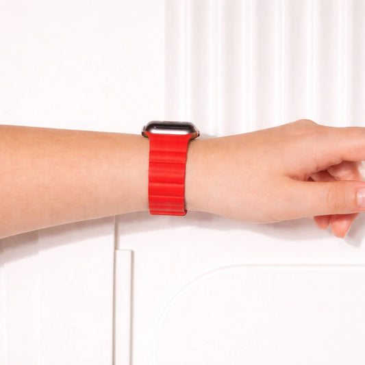 Red two-part leather Apple Watch band worn on the wrist.