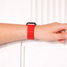 Red two-part leather Apple Watch band worn on the wrist.