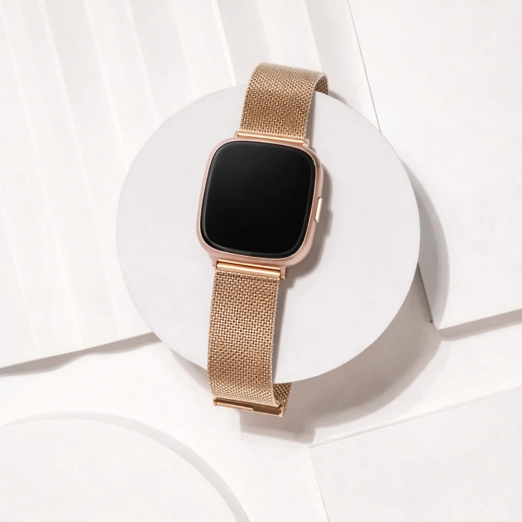 Rose gold metal mesh watch strap compatible with Fitbit Versa 3 on white background