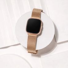 Rose gold metal band for Fitbit Versa 4 shown in a clean flat lay