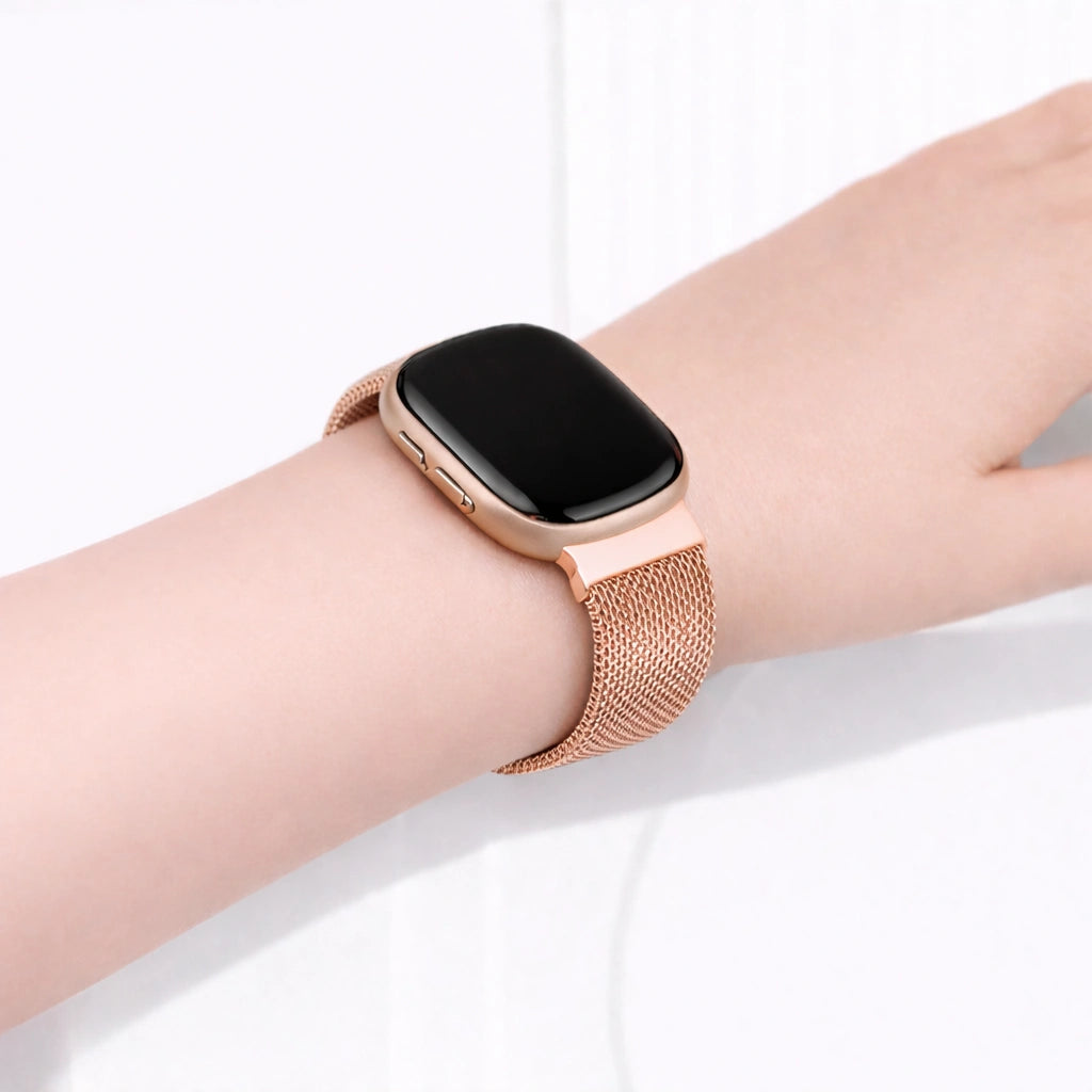 Rose gold Fitbit Sense 2 band worn on the wrist, featuring a breathable mesh watch strap for everyday comfort