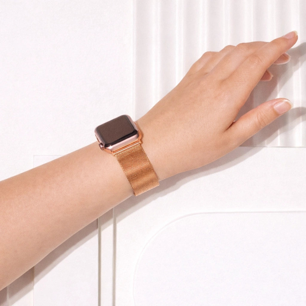 Rose gold metal Apple Watch strap worn on the wrist with a breathable mesh design