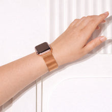 Rose gold metal Apple Watch strap worn on the wrist with a breathable mesh design