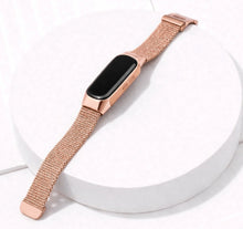 Rose gold Milanese band for Fitbit Inspire 3 shown on a display stand