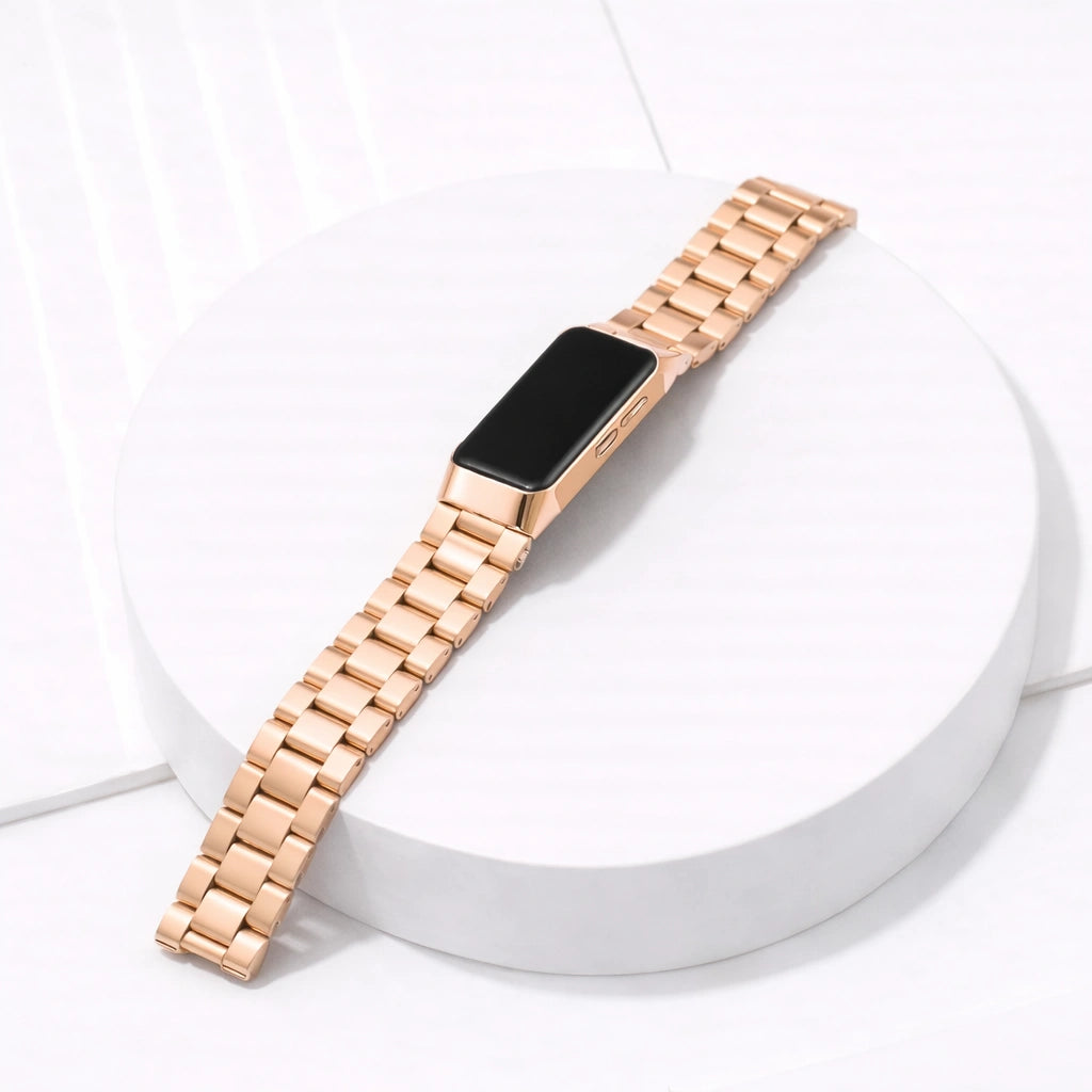 Fitbit Charge 5 rose gold metal watch strap with stainless steel links on white platform