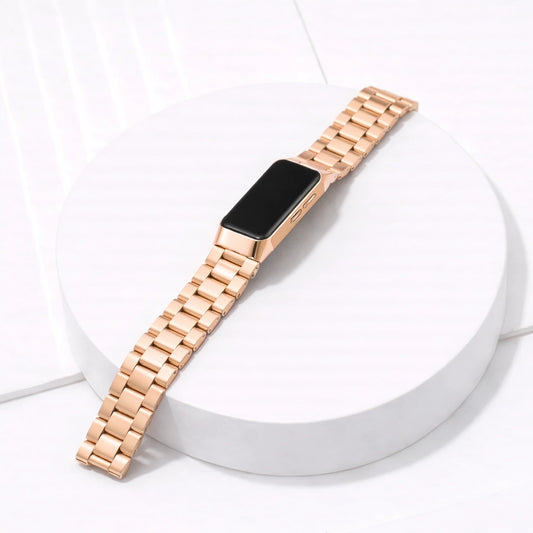 Fitbit Charge 5 rose gold metal watch strap with stainless steel links on white platform