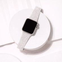 Silver glitter strap for Apple Watch displayed in a minimal flat lay setting