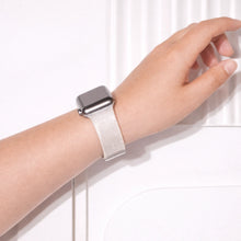 Silver glittery Apple Watch wristband worn on wrist with subtle shimmering finish