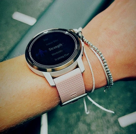 Close-up of a smartwatch with a pink strap during a strength workout