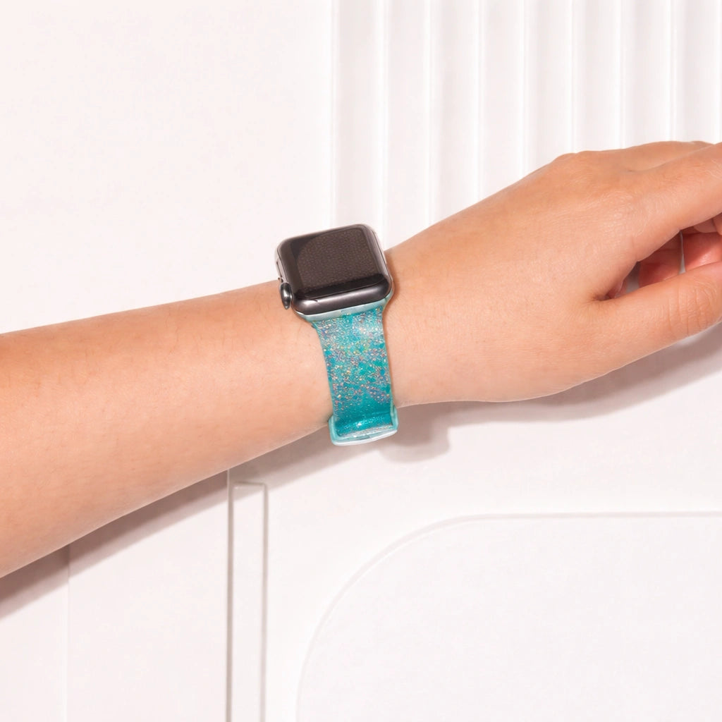 Teal glittery Apple Watch wristband worn on wrist with soft ocean-inspired shimmer