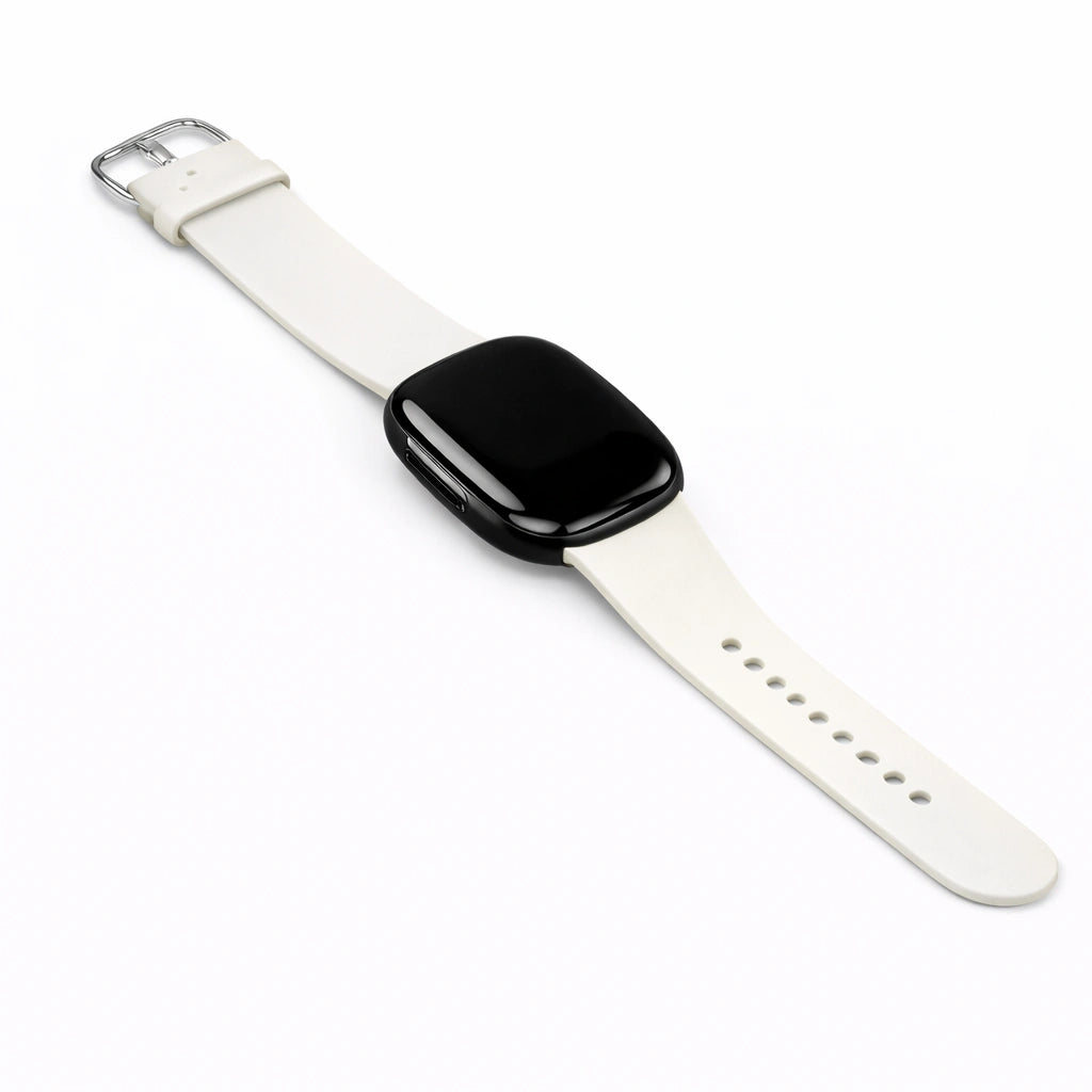 Minimal flat lay of a white silicone band designed for Fitbit Versa 3.