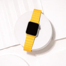 Yellow two-part leather watch strap for Apple Watch displayed on a white platform.