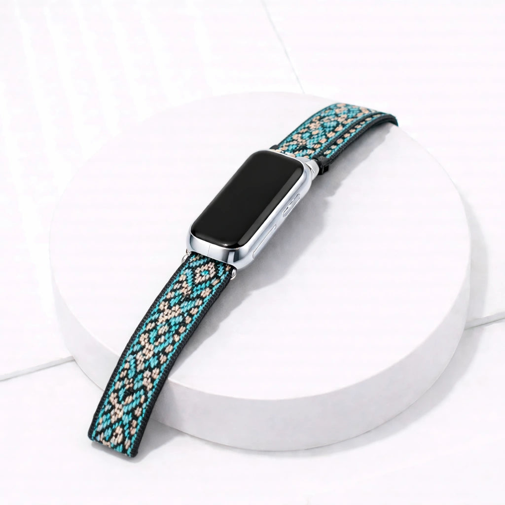 Zig zag pattern nylon fabric watch band for Fitbit Luxe and device on a white display stand