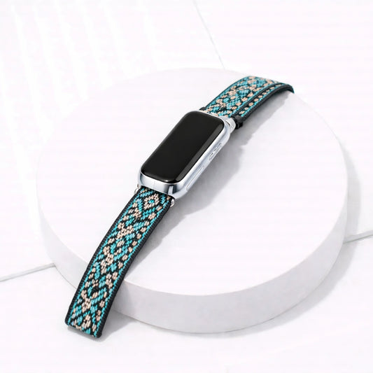 Zig zag pattern nylon fabric watch band for Fitbit Luxe and device on a white display stand
